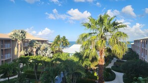 A resort with multiple-story buildings, palm trees, and a well-maintained garden with pathways and seating areas. - Holiday Inn Resort Grand Cayman by IHG (West Bay)