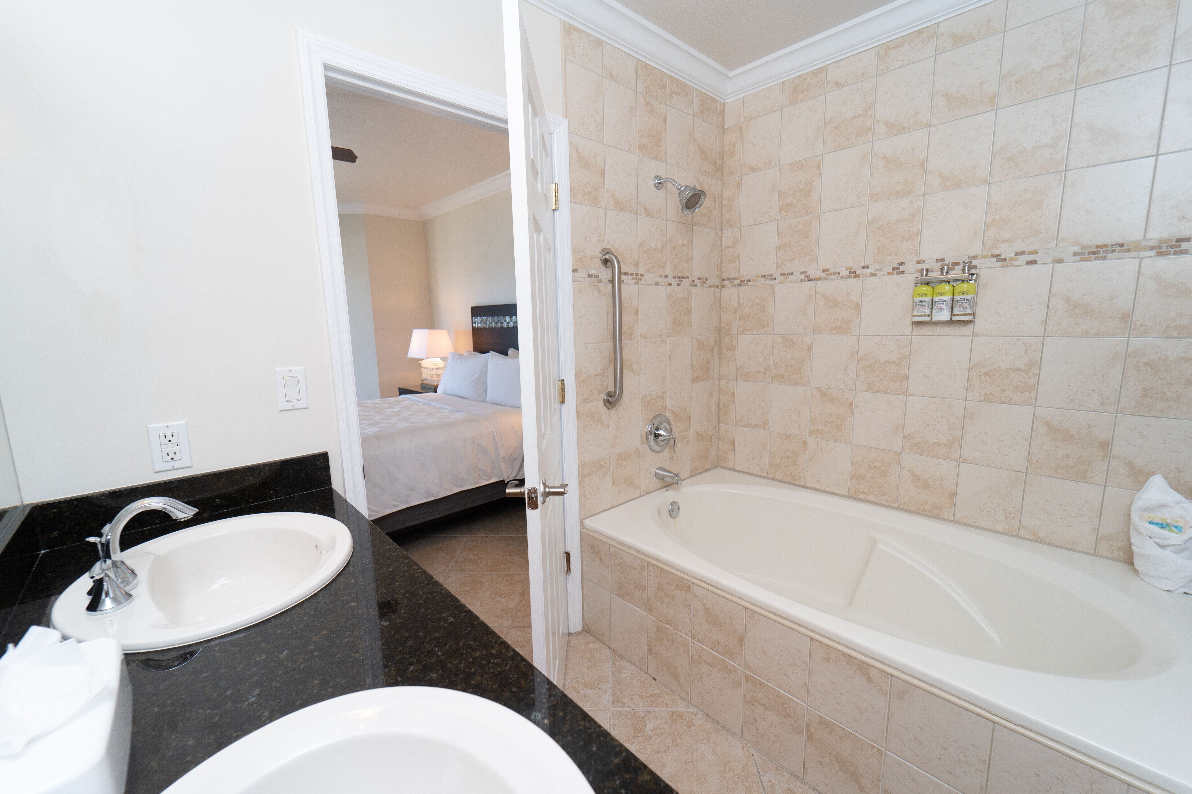 A bathroom with a bathtub, two sinks, and a shower.