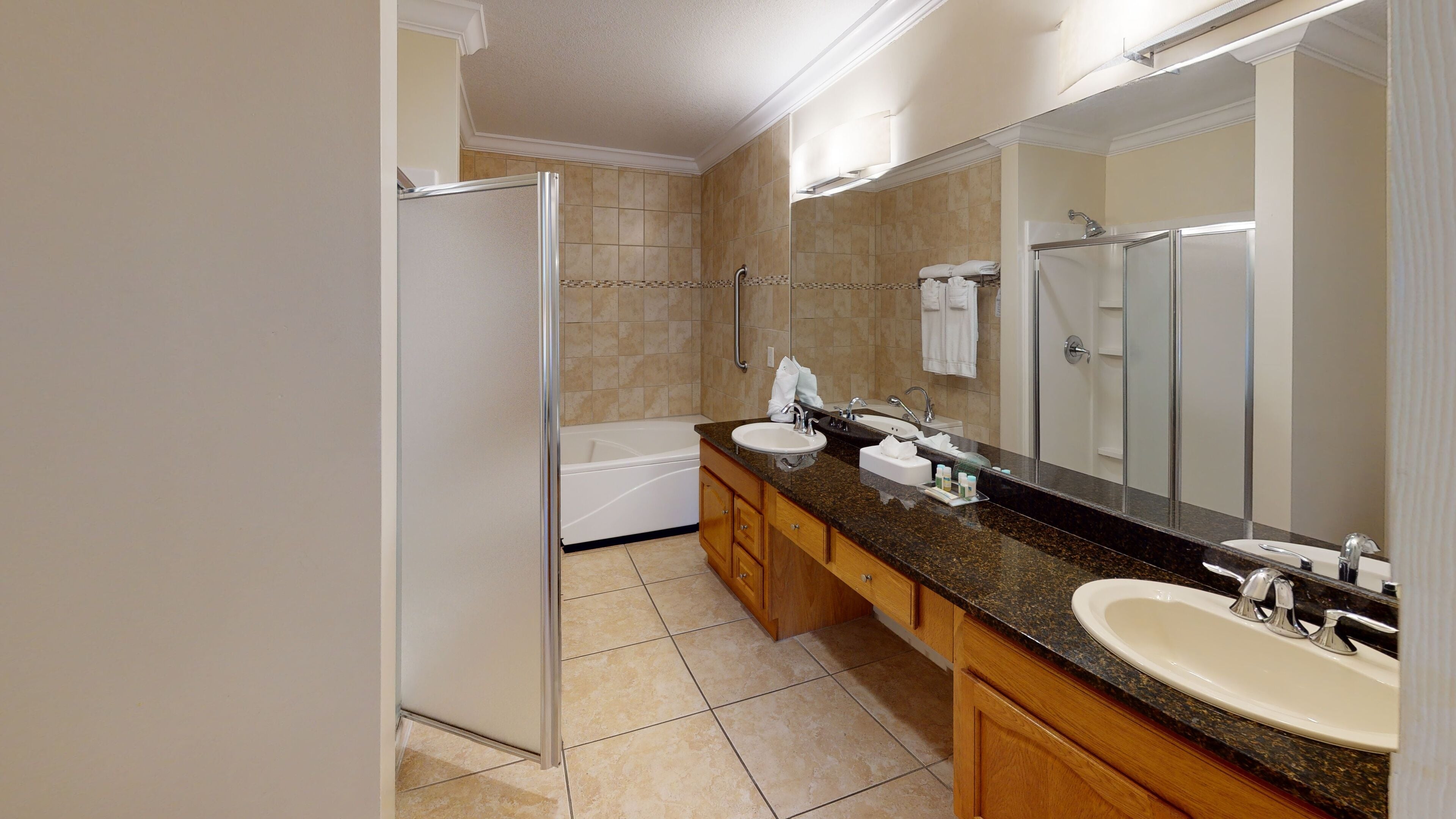Un bagno moderno con un doppio lavabo, una vasca e un grande specchio.