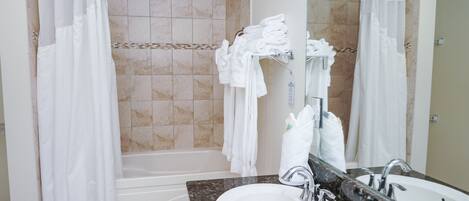 A bathroom with a bathtub, two sinks, and a mirror.