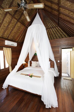 A four-poster bed with a canopy, wooden walls, and a ceiling fan.