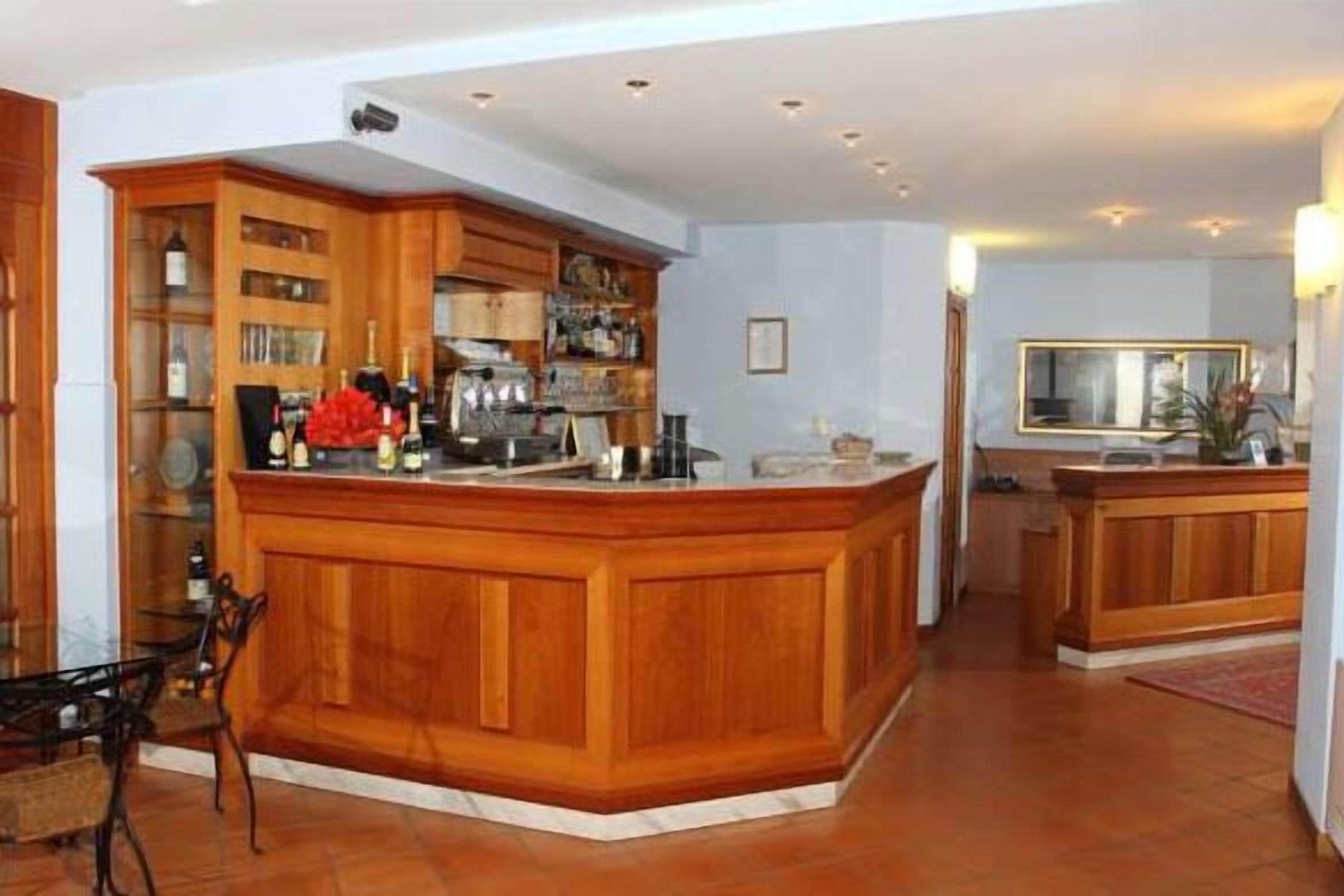 Un'ampia cucina con mobili in legno, un'isola centrale e una zona pranzo con una sedia.