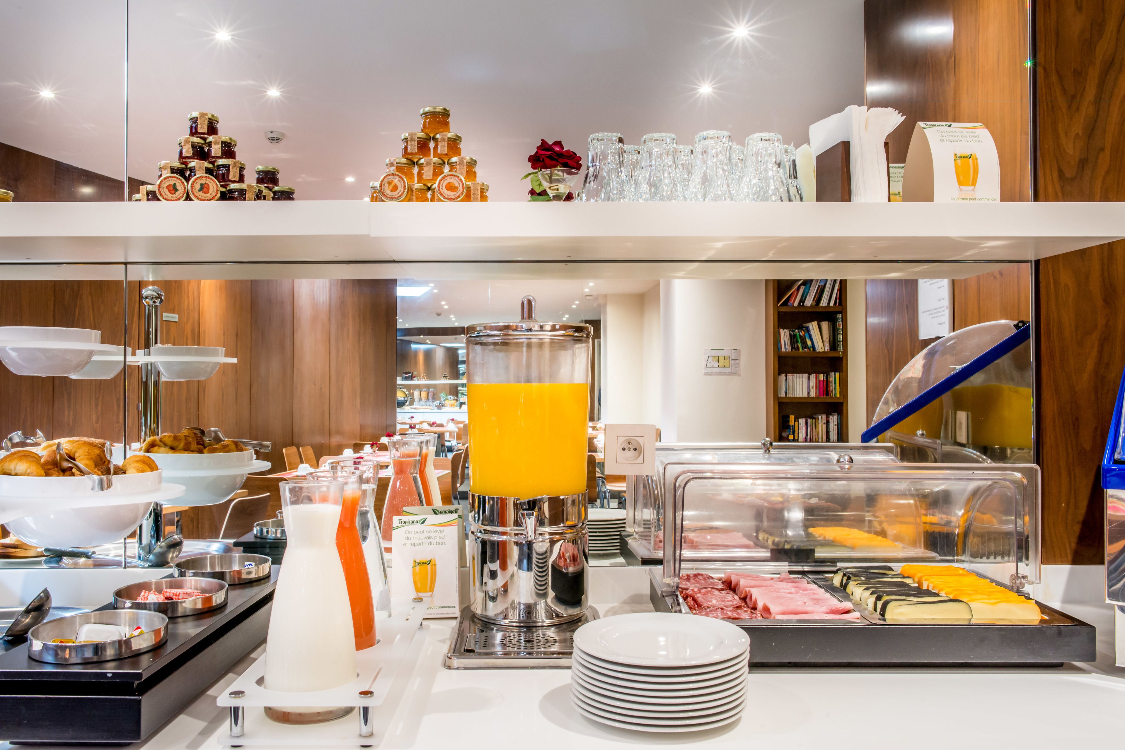 Ein reichhaltiges Frühstücksbuffet mit verschiedenen Speisen, einem Saftspender und einer Kaffeemaschine.