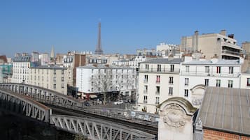 Une vue urbaine avec la Tour Eiffel en arrière-plan, un pont et divers bâtiments.