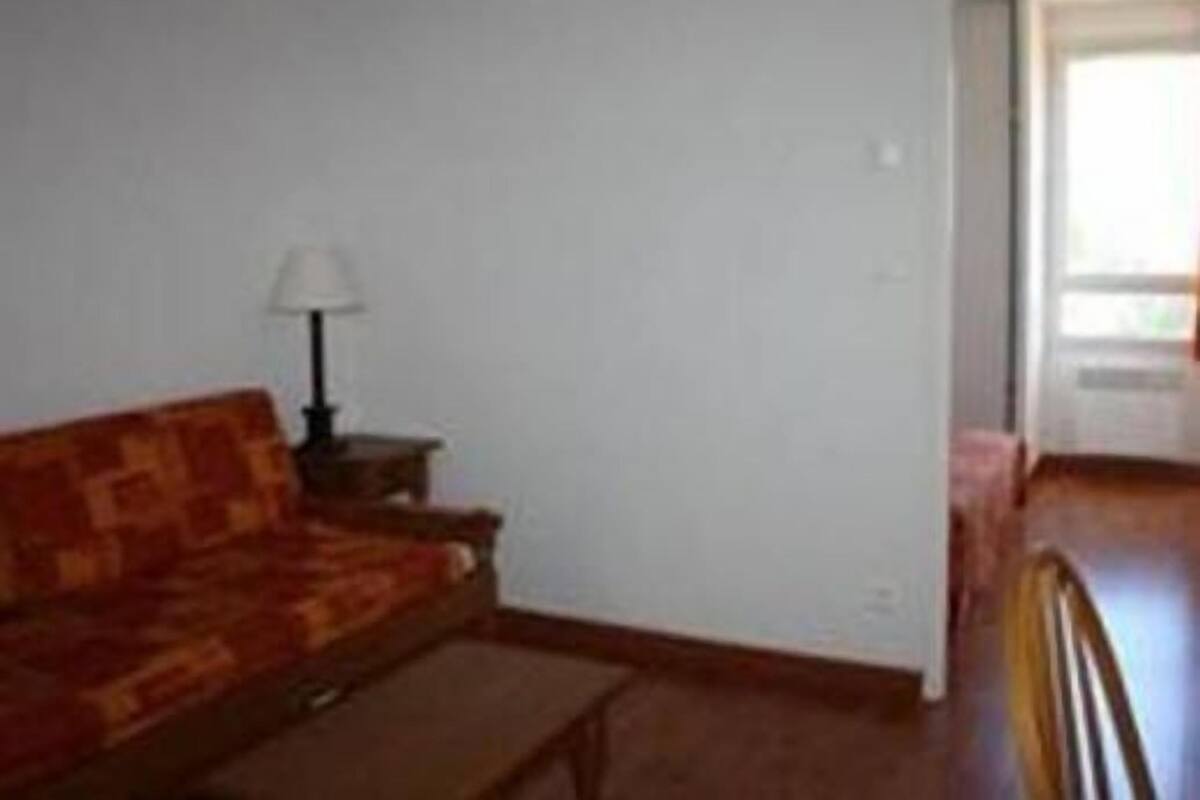 A living room with a sofa, a lamp, and a small table.