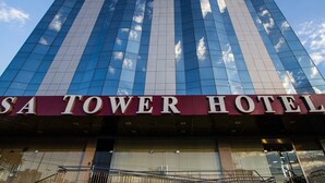 The exterior of the SA Tower Hotel with a modern glass facade reflecting the sky. - Brisa Tower Hotel (Ceilandia)