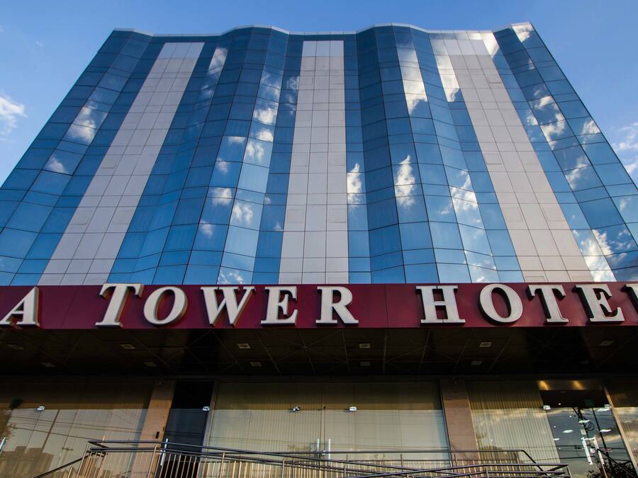 The exterior of the SA Tower Hotel with a modern glass facade reflecting the sky.