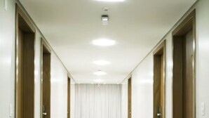 A long, narrow hallway with white walls and doors on both sides. - Brisa Tower Hotel (Ceilandia)