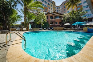 Una piscina al aire libre, sillones reclinables de piscina