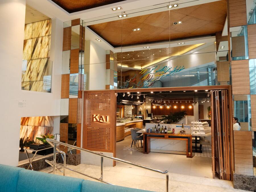 Un hall d’hôtel moderne avec un comptoir d’accueil, un espace salon et une vue sur l’intérieur.