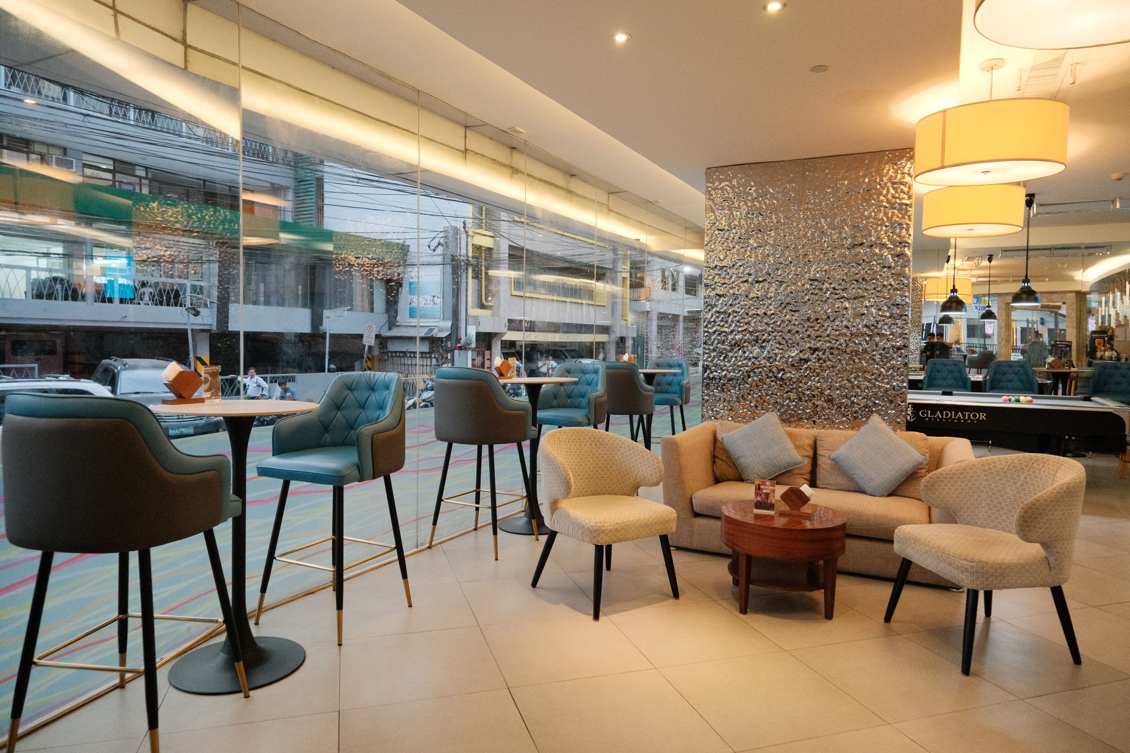 Un espacio interior moderno con distribuciones de asientos, una mesa de billar y un muro decorativo.