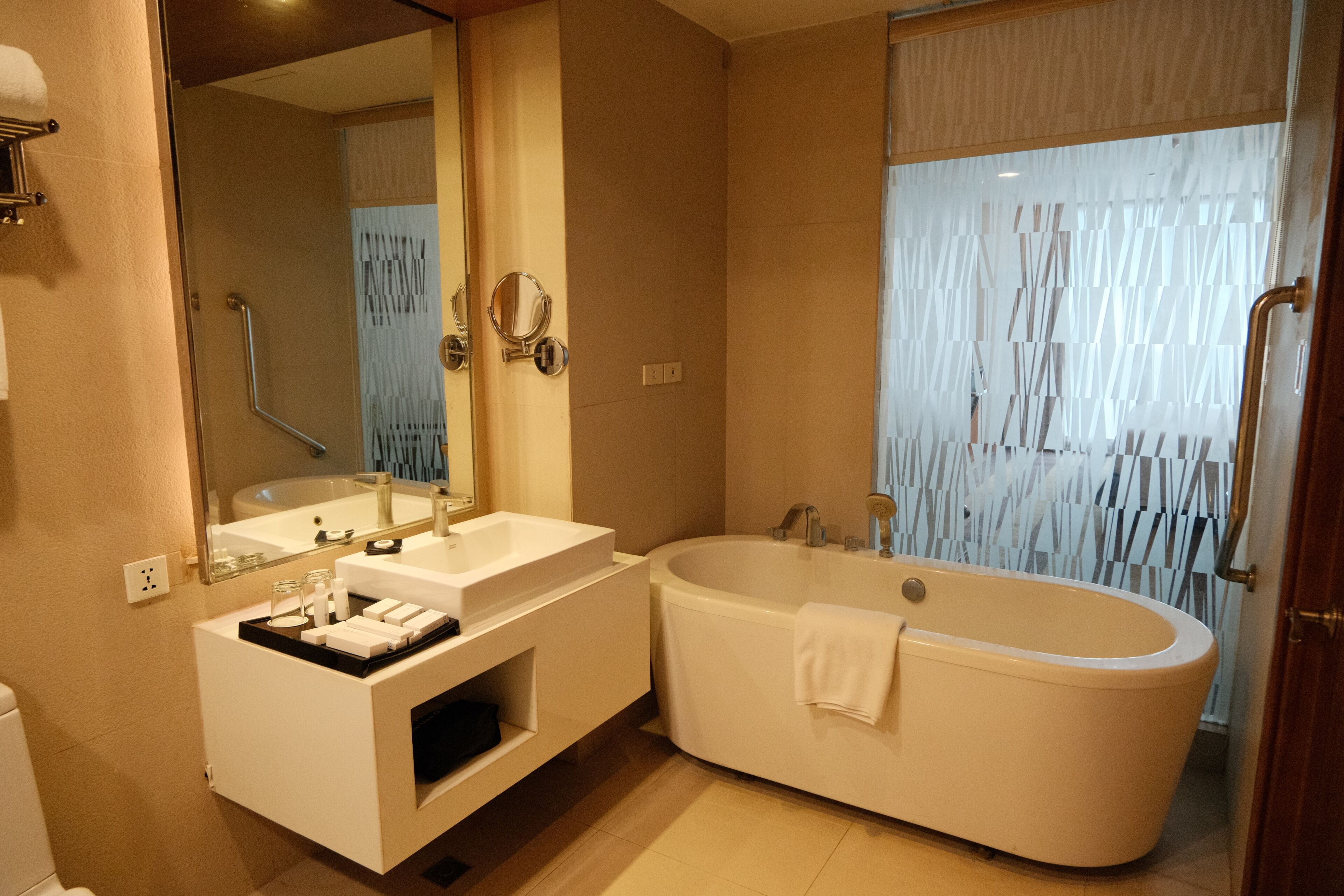 A modern bathroom with a freestanding bathtub, a vanity with a mirror, and a shower area.