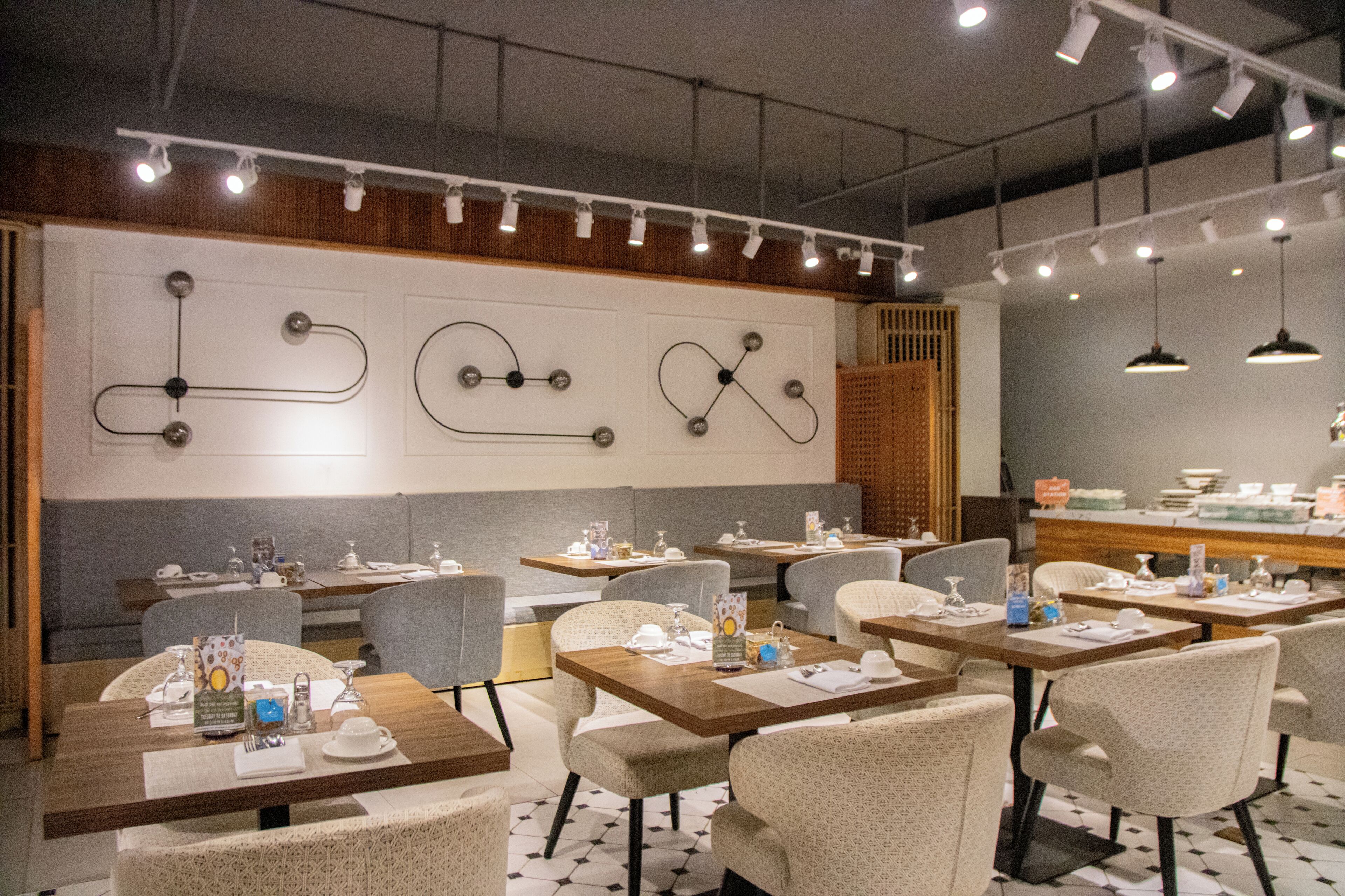 A restaurant interior with tables, chairs, and a wall-mounted light fixture.