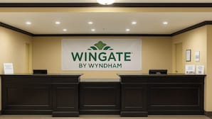 A reception desk with a sign that reads 'Wingate by Wyndham.' - Wingate by Wyndham Fort Saskatchewan (Fort Saskatchewan)