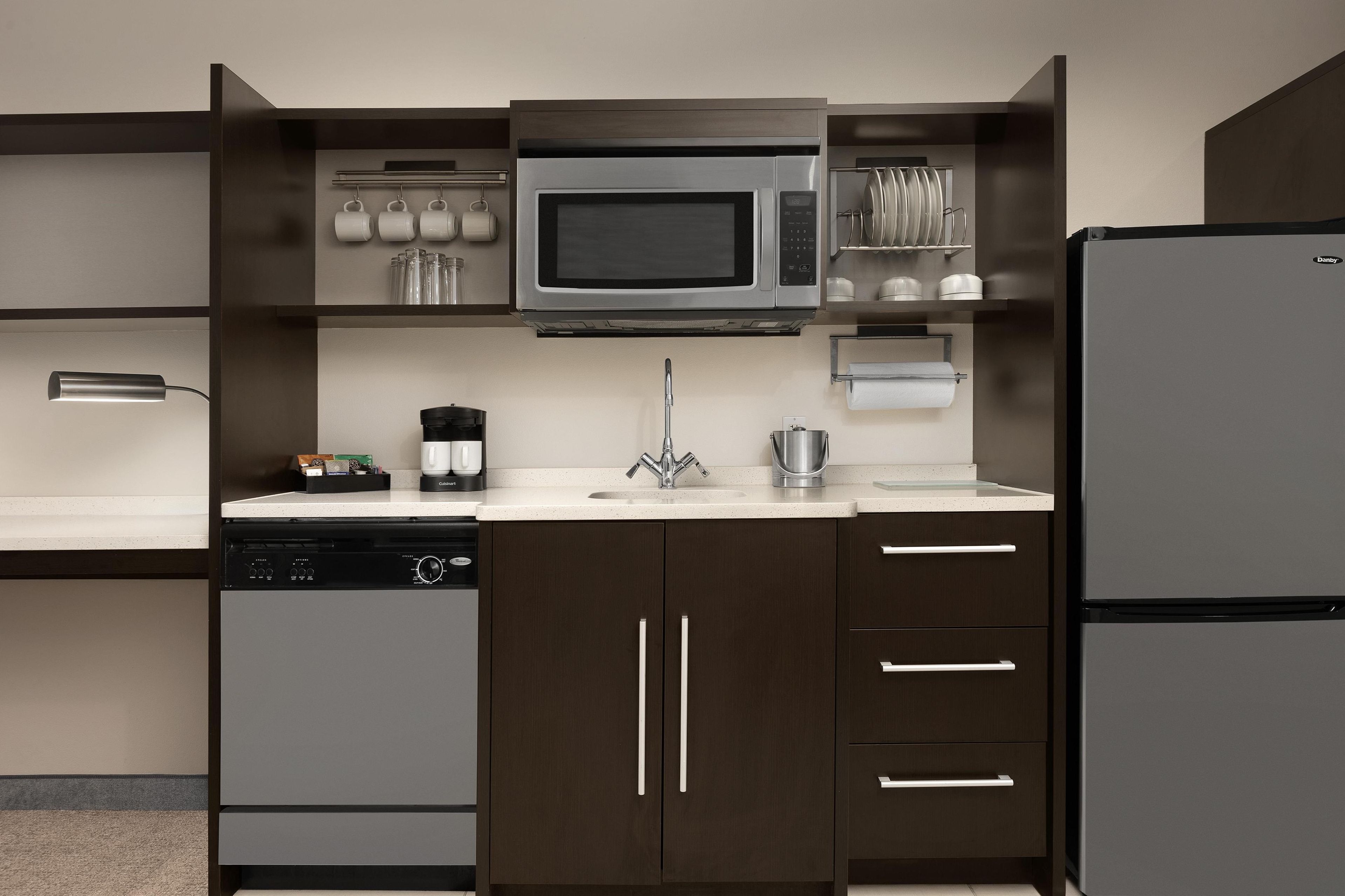 A modern kitchen with a built-in microwave, dishwasher, and refrigerator.