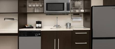 A modern kitchen with a built-in microwave, dishwasher, and refrigerator.