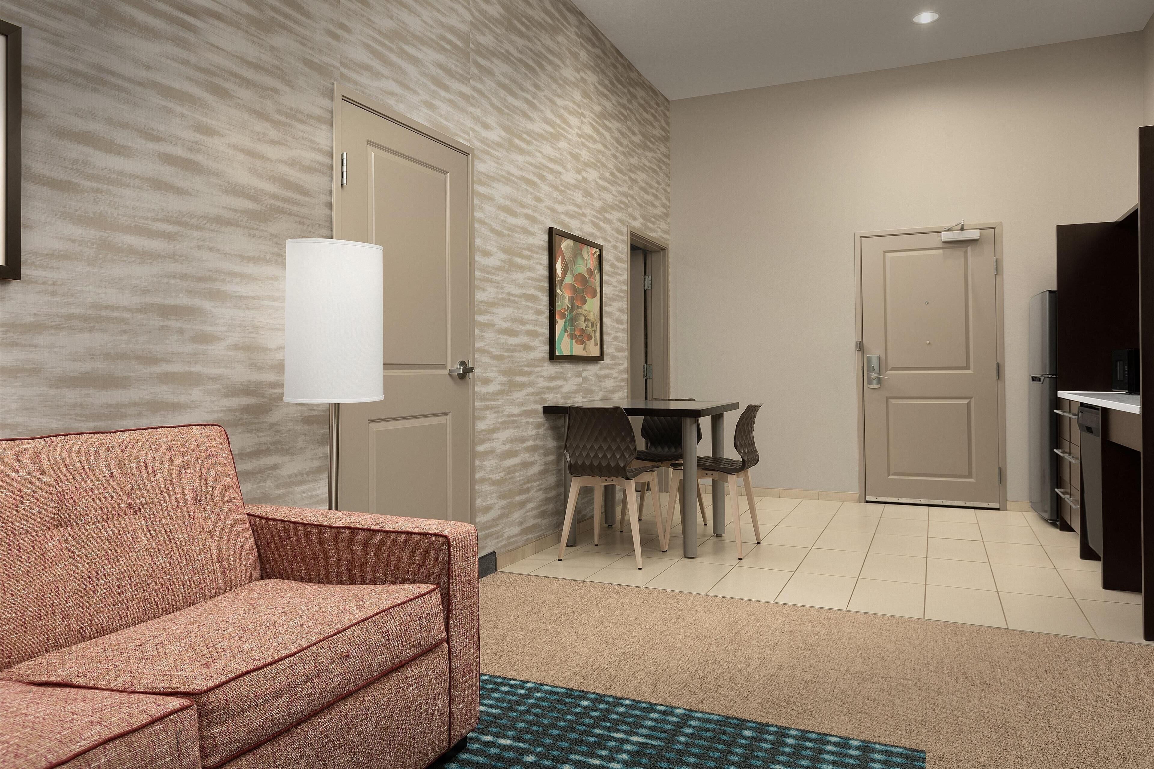 A compact living space with a sofa, a dining table with chairs, and a TV stand.