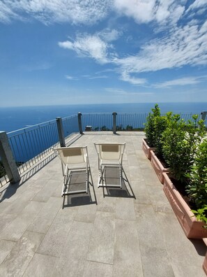 A terrace with two chairs and a view of the sea. - Hotel Due Gemelli (Riomaggiore)