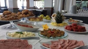 Una mesa de buffet con diversos platos, incluyendo pasteles, frutas y carnes.
