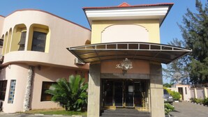 A building with a curved facade, a central entrance with a canopy, and a sign that reads "Hotel". - Solitude Hotel Victoria Island (Lagos)