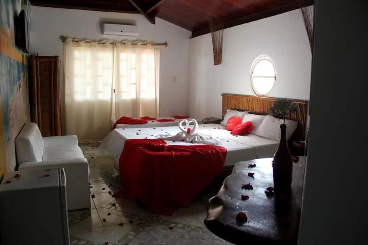 A bedroom with two beds, a sofa, and a small table.