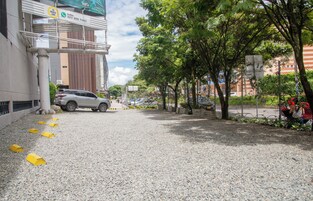 A gravel driveway leading to a building with a parked car.