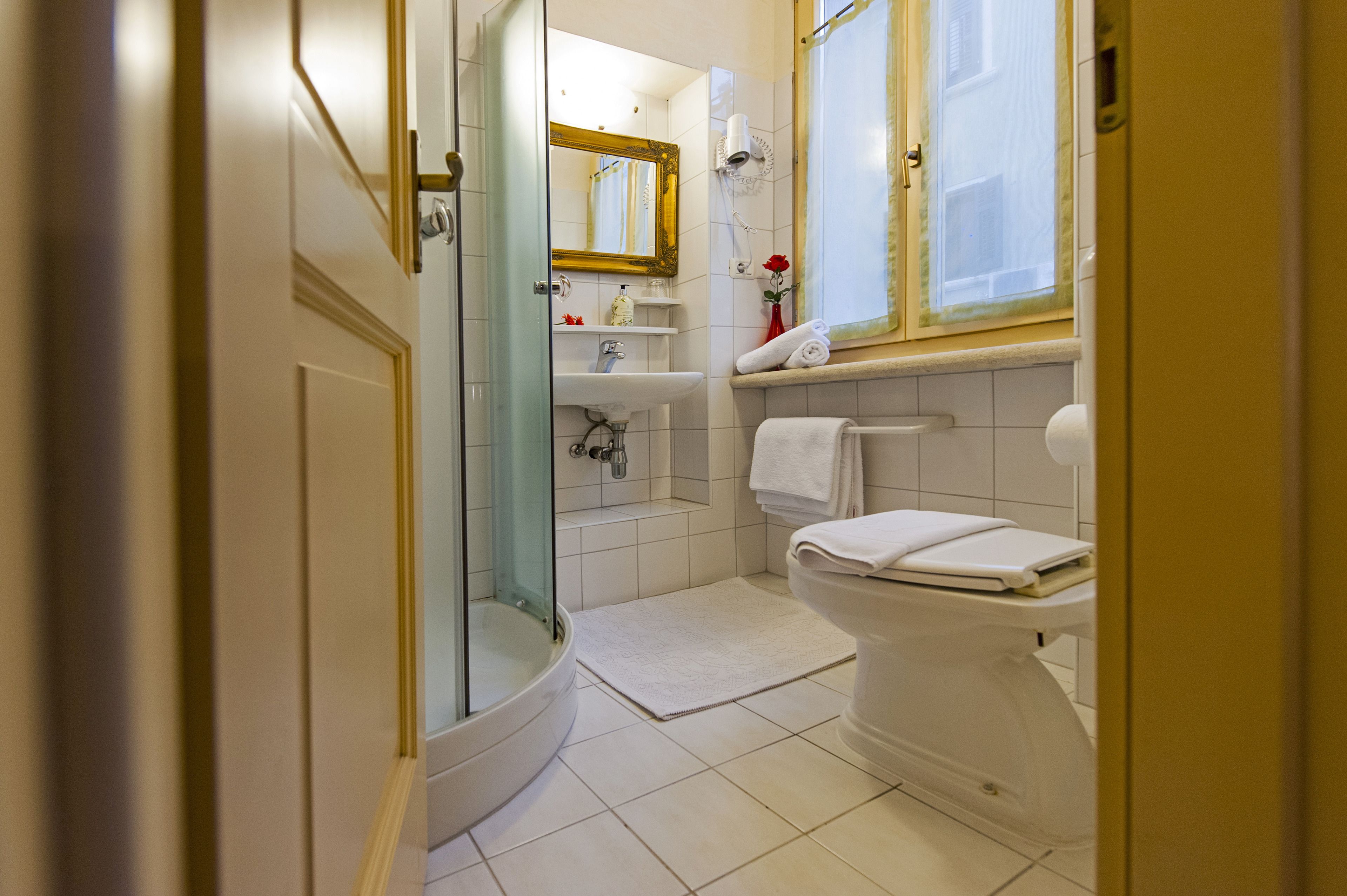 Un bagno moderno con doccia vetro-murata, lavabo bianco e water.