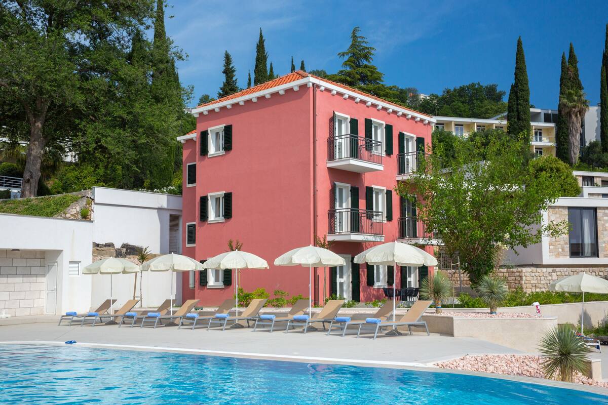 Un hôtel doté d’une piscine, de chaises longues et de parasols.