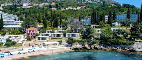 En la playa, sillas reclinables de playa, sombrillas, bar en la playa