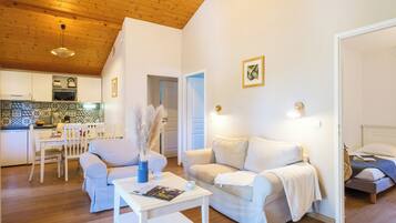 Una sala de estar moderna con un sofá blanco, una mesa de centro y un comedor con una mesa y sillas blancas.