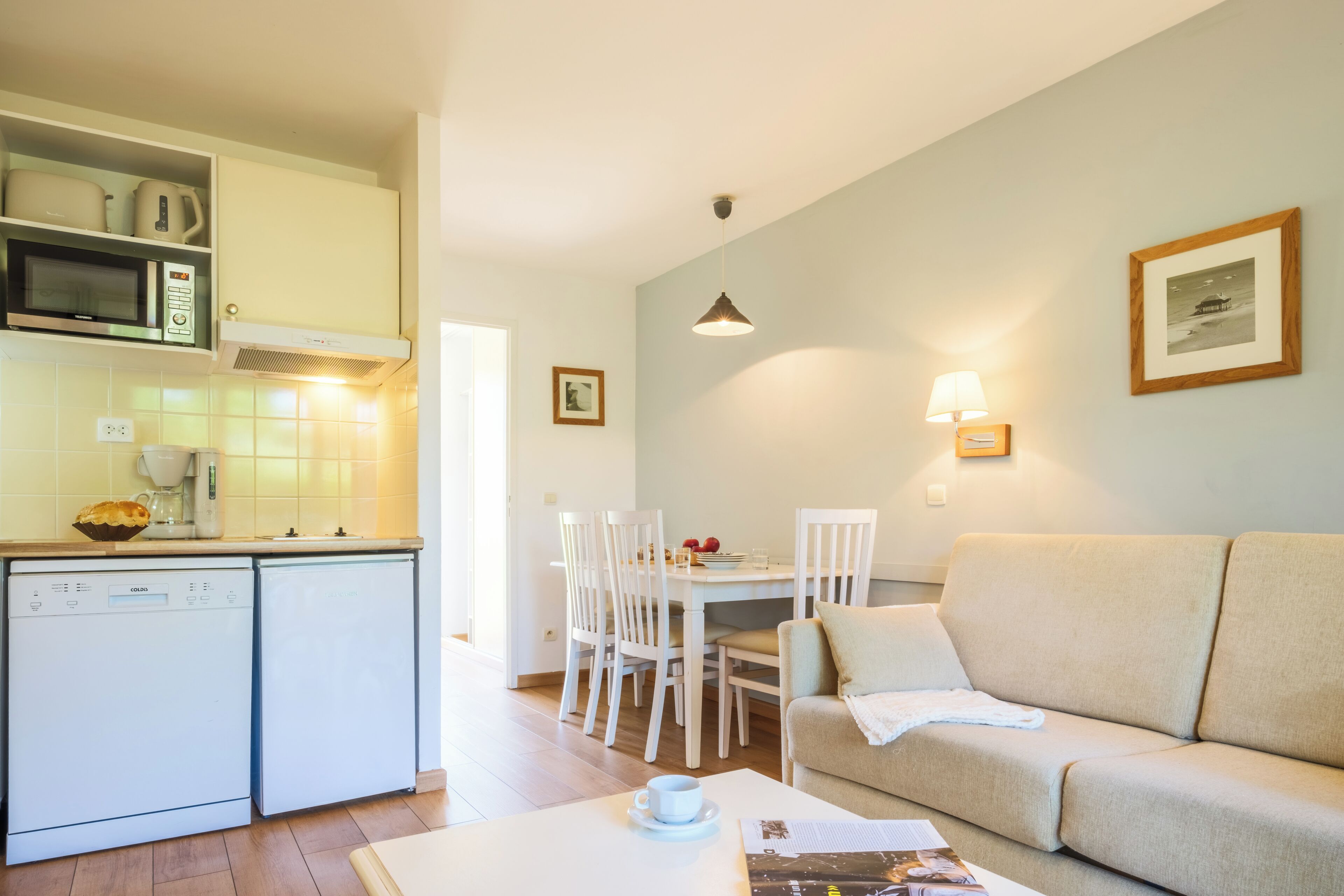 A compact living space with a kitchenette, dining area, and a sofa.