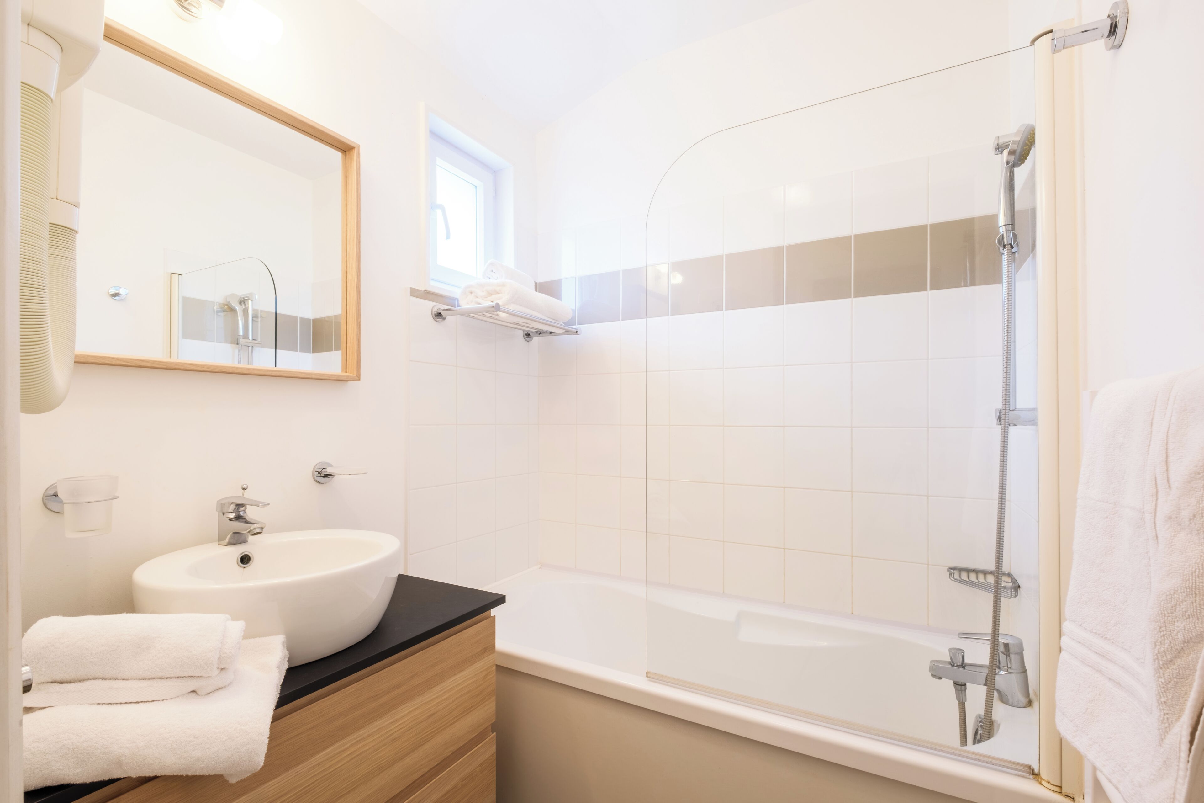 Une salle de bain moderne avec un lavabo, un miroir et une douche.
