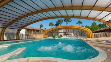 Una piscina cubierta, una piscina al aire libre de temporada, sombrillas