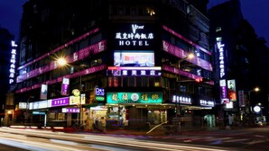 Ein mehrstöckiges Hotel mit beleuchteter Beschilderung, darunter ein gut sichtbares Schild mit 'Vone Hotel'.