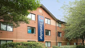 A Travelodge hotel with a brick facade, large windows, and a signboard. - Travelodge Derby Chaddesden (Derby)