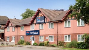 A Travelodge hotel with a brick facade, multiple windows, and a clear sky. - Travelodge Derby Chaddesden (Derby)
