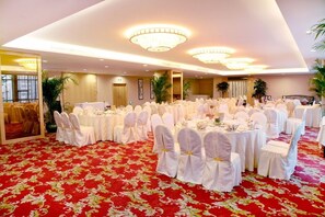 A banquet hall with round tables, white tablecloths, and chairs with white covers. - Grand Soluxe International Hotel Nanning (Nanning)