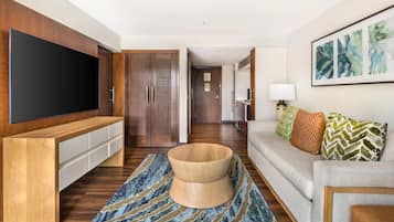 Ein modernes Wohnzimmer mit Flachbildfernseher, einer Holz-Unterhaltungseinheit, einem runden Holztisch und einem gemusterten Teppich.