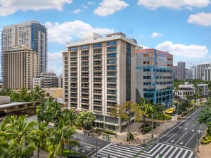 A high-rise building with multiple floors, a pedestrian walkway, and palm trees. - Hilton Grand Vacations Club Hokulani Waikiki Honolulu (Honolulu)