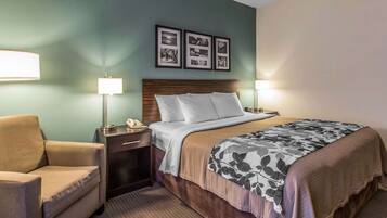 A hotel room with a bed, two bedside lamps, a chair, a nightstand with a phone, and three framed pictures on the wall.