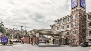 Ein Sleep Inn & Suites Gebäude mit überdachter Parkfläche und einer Tankstelle.