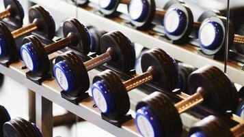 Eine Reihe von Hanteln auf einem Gestell im Fitnessstudio.