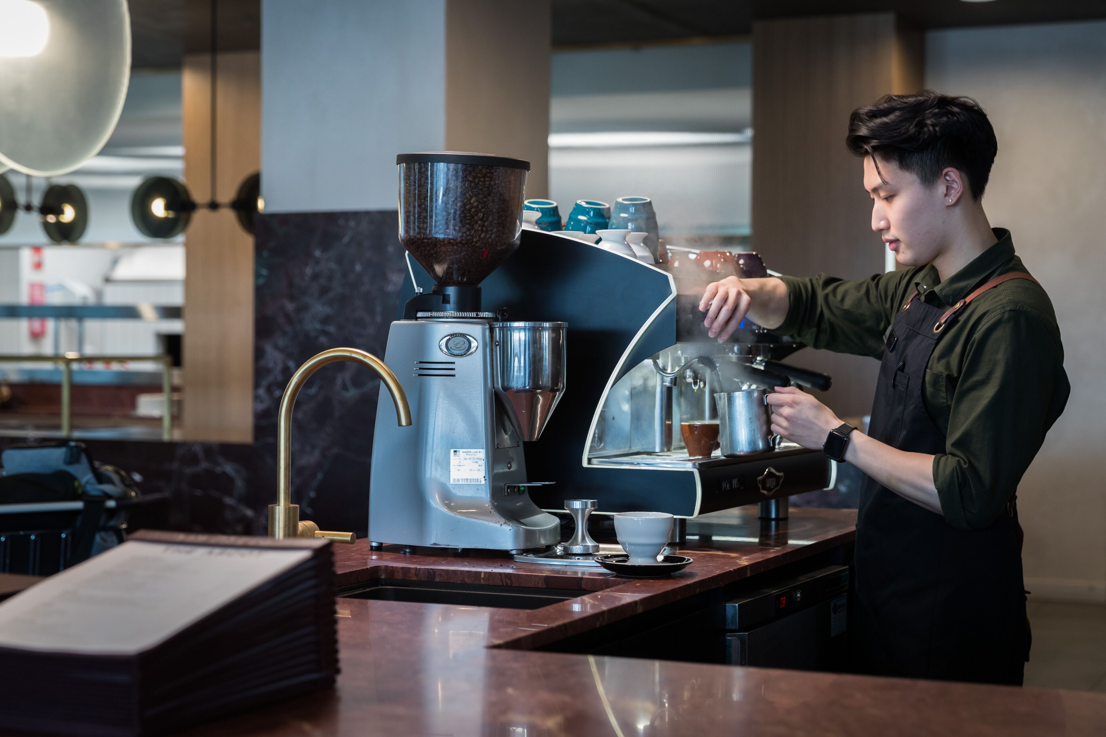 A coffee machine with a portafilter and a cup of coffee on a counter.
