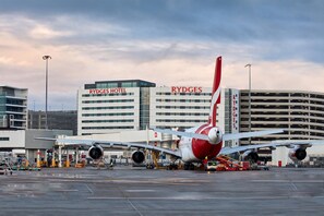 Un aeropuerto con un hotel RyDges al fondo.