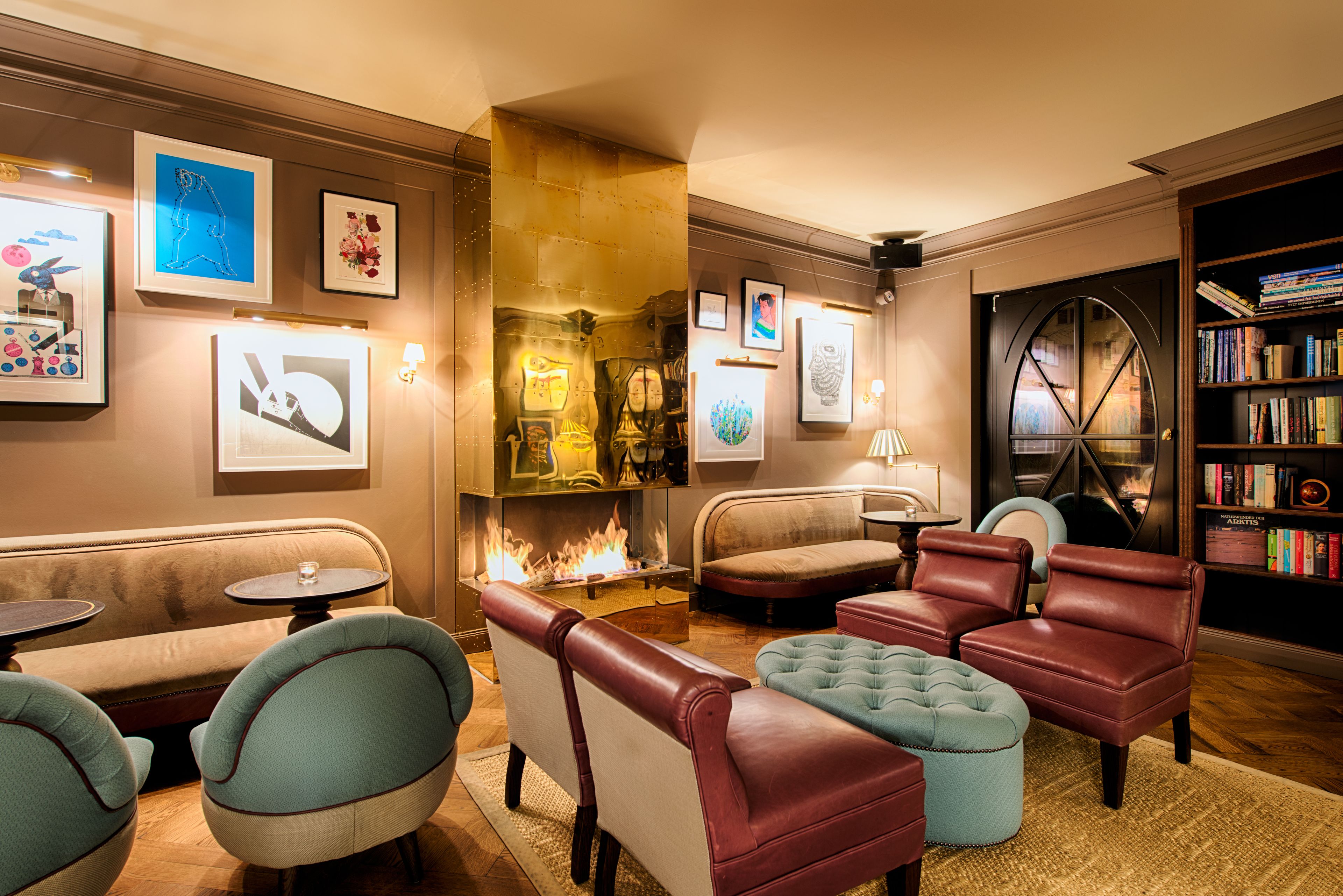 A cozy lounge area with leather sofas, a fireplace, and framed artwork on the walls.
