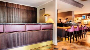Eine Bar mit einer Holzwand, einer gepolsterten Bank und mehreren Barhocker.
