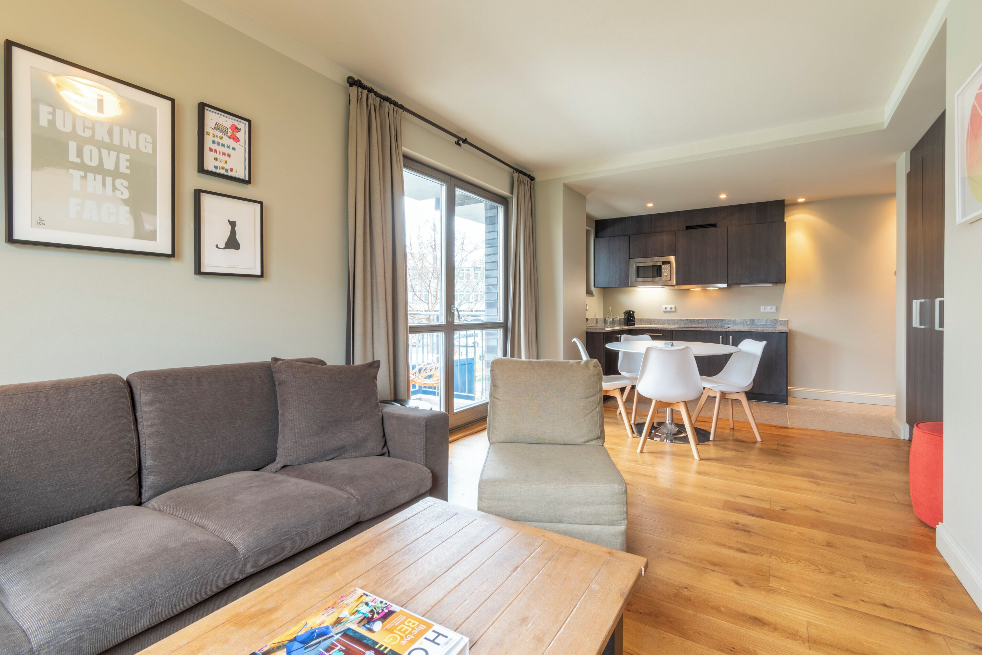 Ein modernes Wohnzimmer mit Sofa, Couchtisch und Essbereich mit Stühlen.