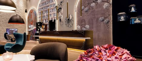 A modern interior with a reception desk, seating area, and decorative wall art.