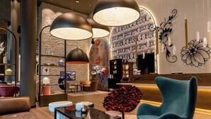 A modern lobby with a seating area, a reception desk, and decorative wall art. - Motel One Dresden Am Zwinger (Dresden)