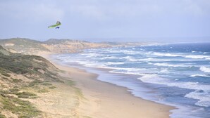 Una playa con una duna y una silla.
